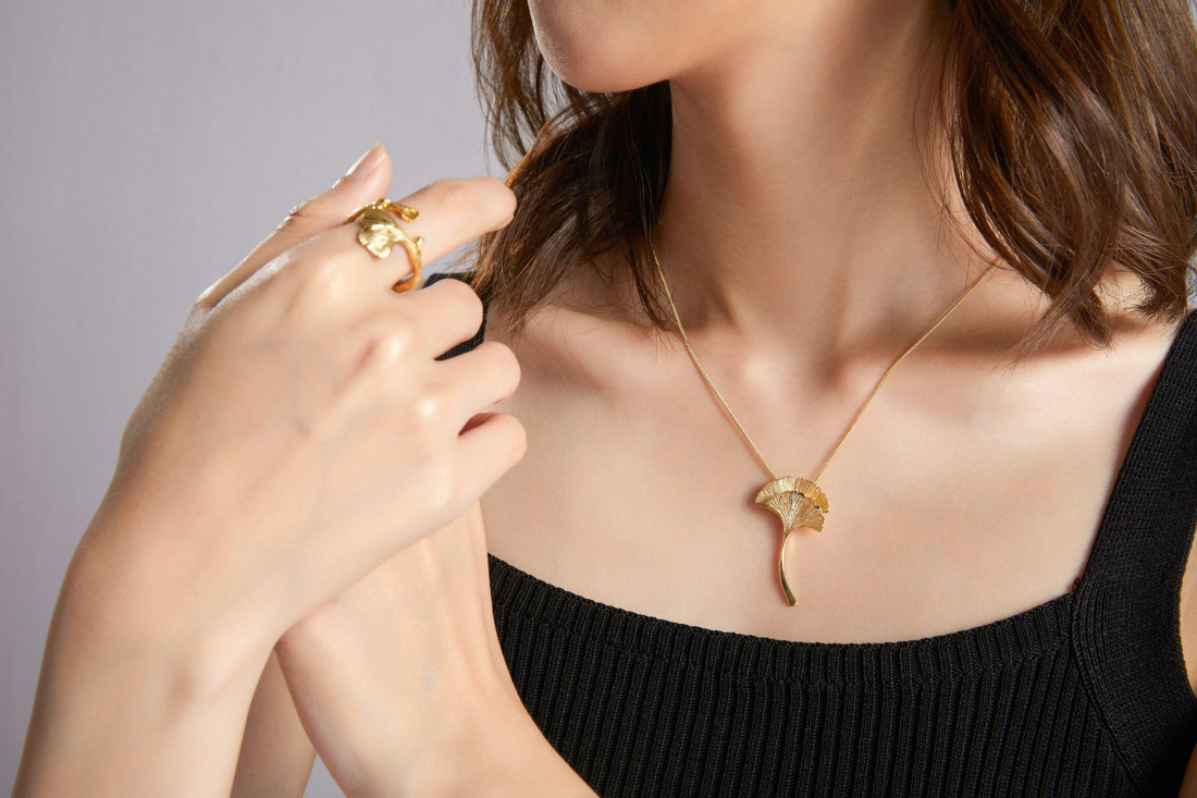 woman wearing a gold necklace and ring close-up