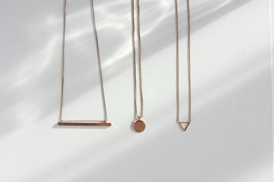Minimal geometric pendant necklaces with bar, circle, and triangle shapes